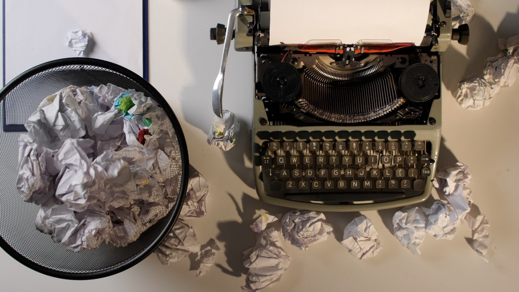 Typewriter surrounded by crumpled pages, representing writer's block